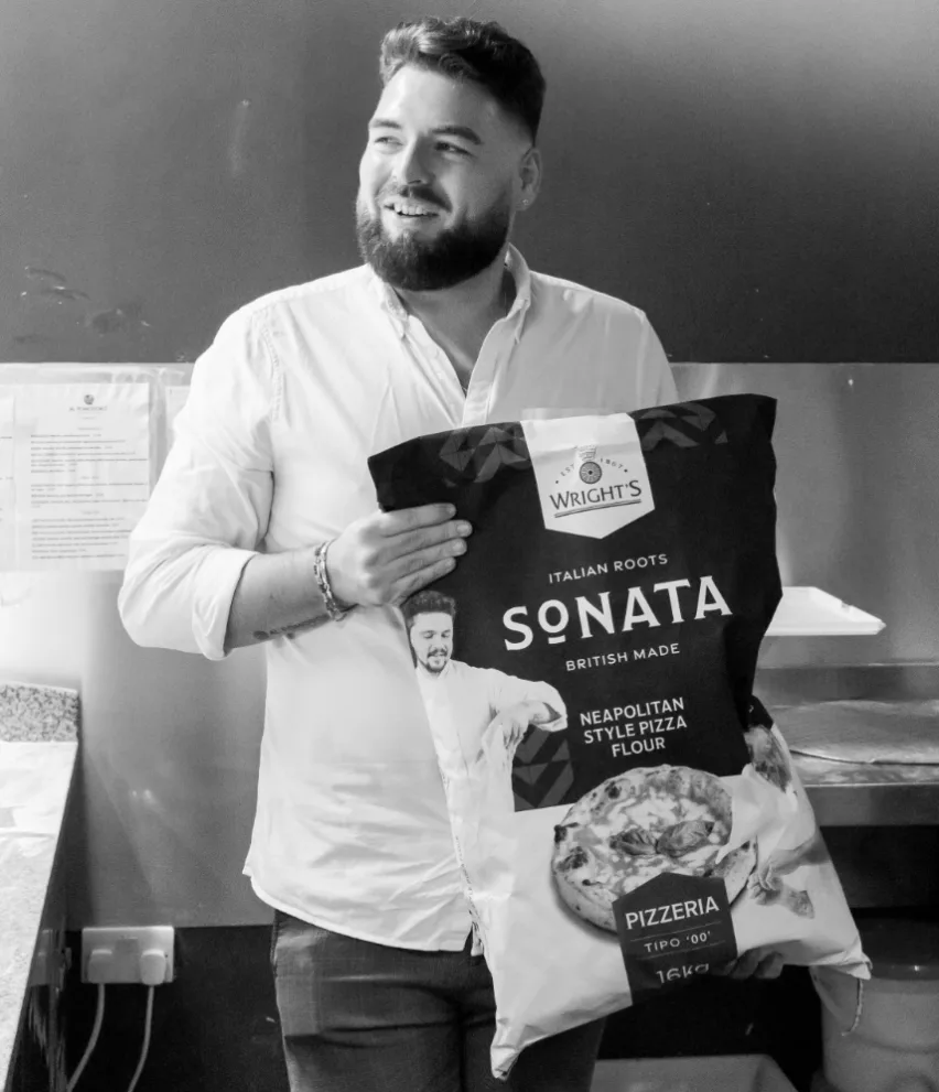 Sonata Neapolitan-style pizza flour is being held by a professional Italian pizza chef. Image in black and white.